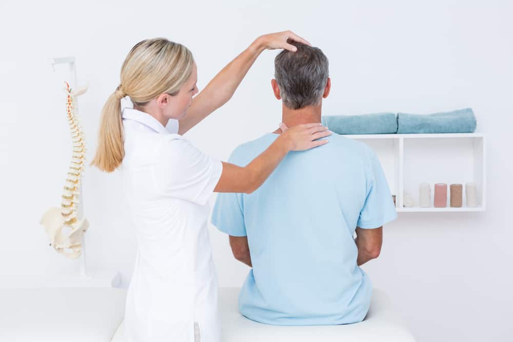 Doctor doing neck adjustment in medical office